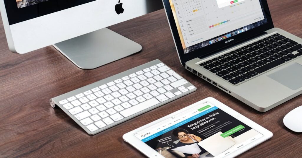 A sleek office desk setup featuring Apple devices: iMac, MacBook, and iPad.